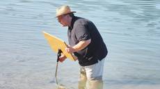 Taufgottesdienst am Badestrand in Brennet (Wehr); Pfarrer Peter Hasenbrink platziert ein Lesepult im Rhein